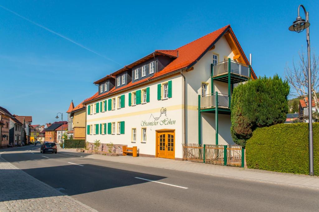 Staimicher Höhen - Premium Appartements في Kurort Steinbach-Hallenberg: مبنى ابيض كبير بسقف احمر على شارع