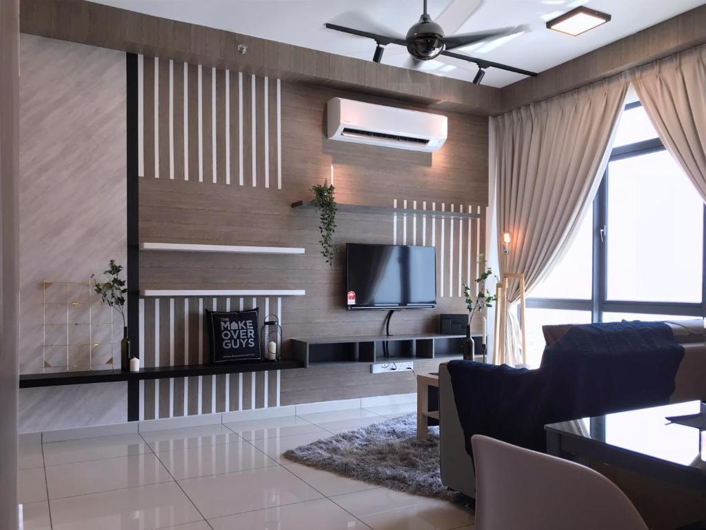 un salon avec une cheminée et une télévision dans l'établissement Kenwingston Square Garden By IdealHub, à Cyberjaya