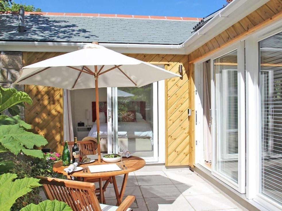 a patio with a table and an umbrella at Cot Valley Cottage in St. Just