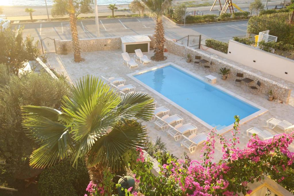 uma vista sobre uma piscina com espreguiçadeiras em Apartments Mladen - family friendly & amazing location em Vrsi