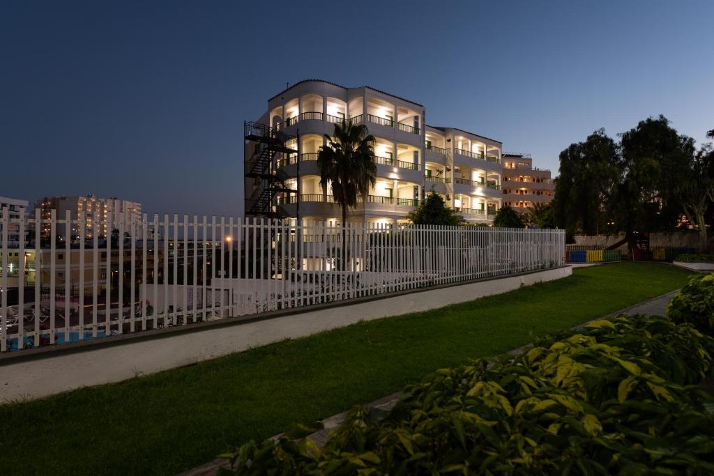 un bâtiment avec une clôture devant une cour dans l'établissement TC Apartamentos Don Diego, à Playa del Ingles