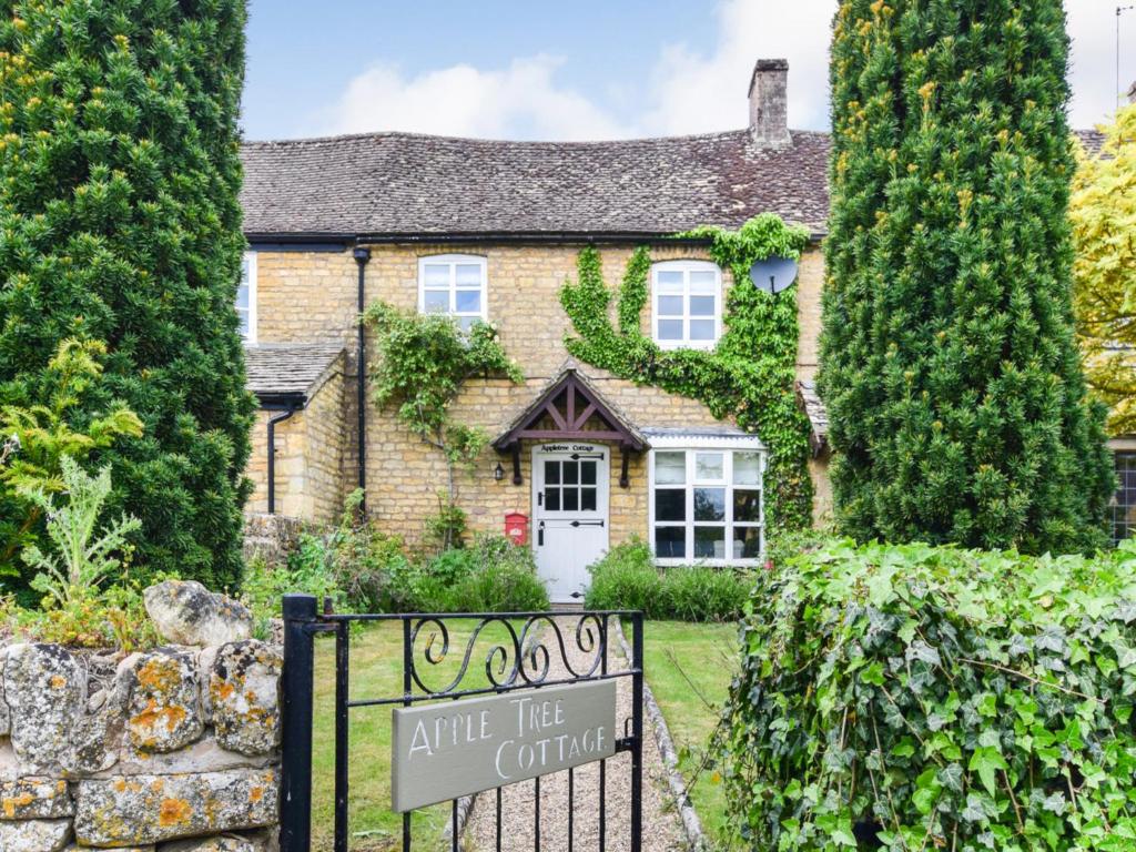 une maison avec un panneau d'entrée devant elle dans l'établissement Appletree Cottage, à Bourton-on-the-Water