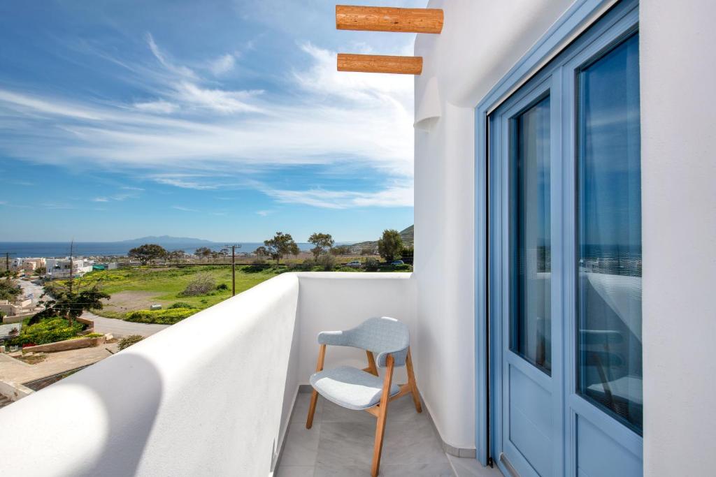 a chair sitting on a balcony looking out at the ocean at La Boheme Villas in Éxo Goniá