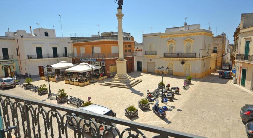 un groupe de personnes assises autour d'une cour dans une ville dans l'établissement I Nidi di Colombo, à Castrignano del Capo