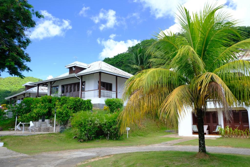 a palm tree in front of a house at La Residence in Baie Lazare Mahé