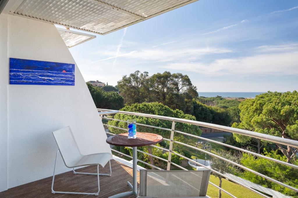 einen Balkon mit einem Tisch und einem Stuhl sowie Meerblick in der Unterkunft Romy in Vale do Lobo