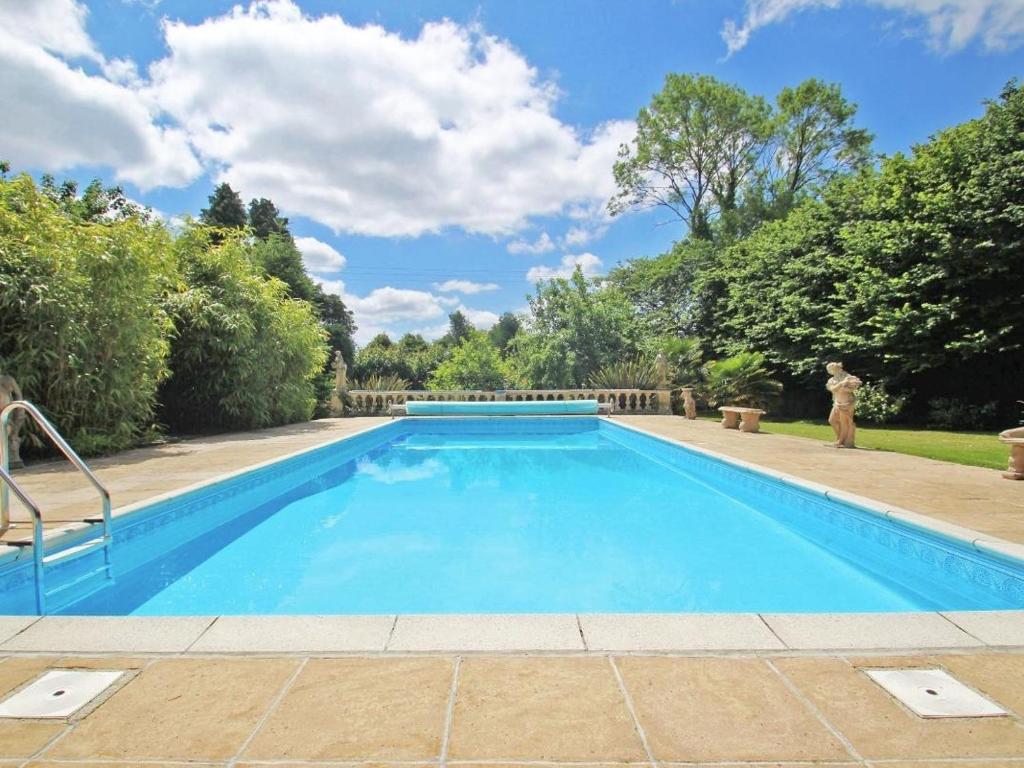 a large blue swimming pool with a person standing next to it at Cider Cottage in Looe