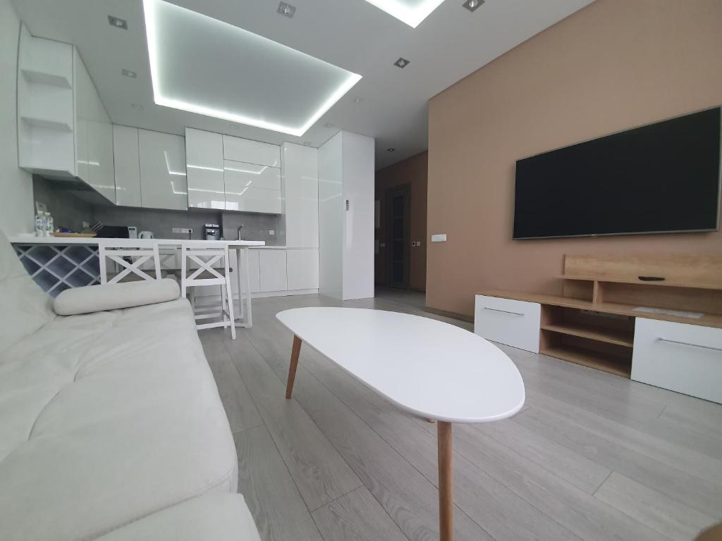 sala de estar con mesa blanca y TV en LuxApartment, en Kiev