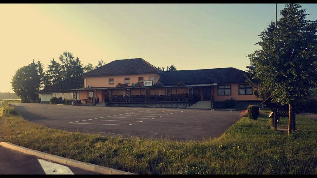 a building with a parking lot in front of it at Gostišče pri Slavcu in Šentjernej