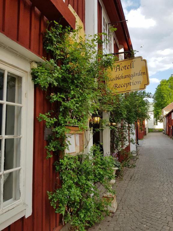 a sign on the side of a building with plants at Hotell Vaxblekaregården in Eksjö