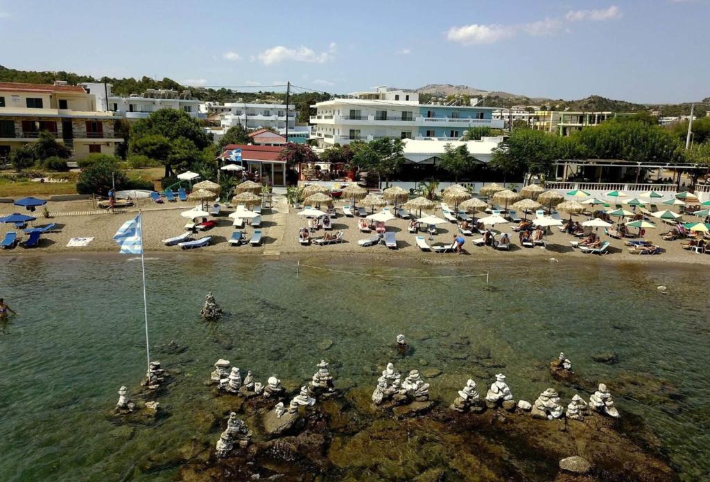 un grupo de personas en el agua en una playa en Tsambikos Apts, en Faliraki