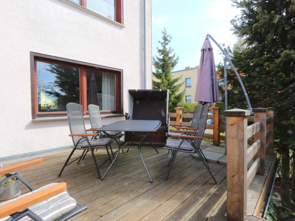 patio con tavolo, sedie e ombrellone di Ferienhaus Rubert Zempin Fewo cc a Zempin