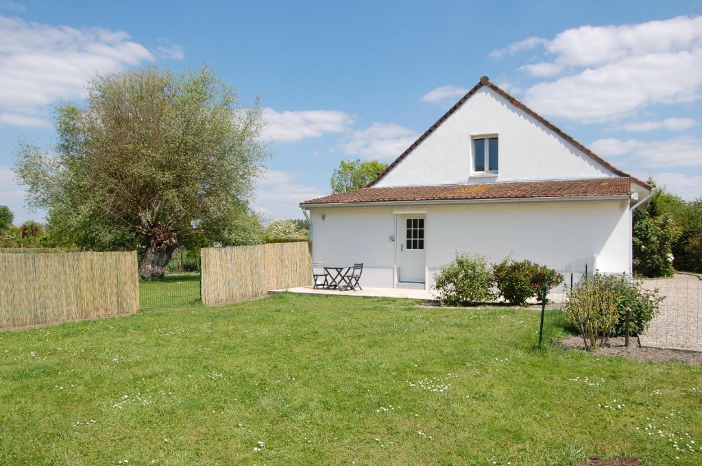 une maison blanche avec une clôture dans une cour dans l'établissement Chez Poussin, à Verton