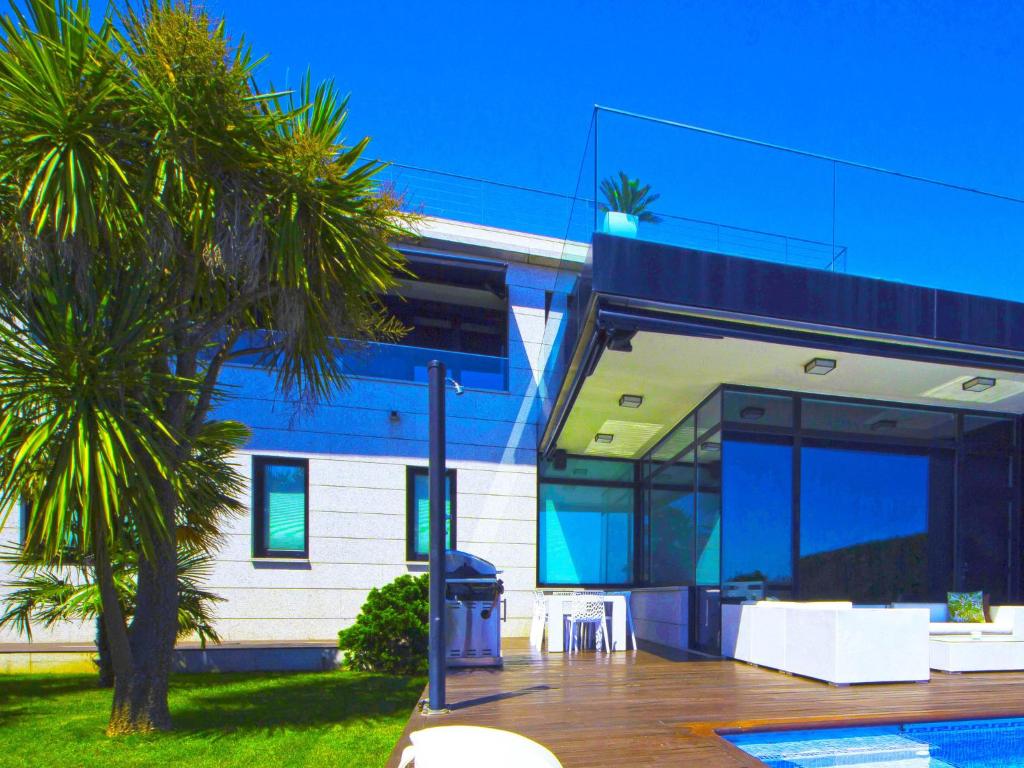 una casa con una palmera delante en Belvilla by OYO Villa Catro Faros, en Montalvo