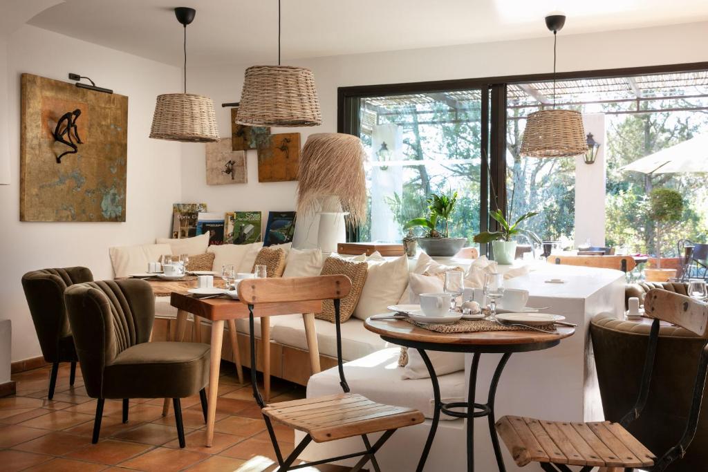a restaurant with tables and chairs and a couch at Domaine Santa Giulia Palace in Porto-Vecchio