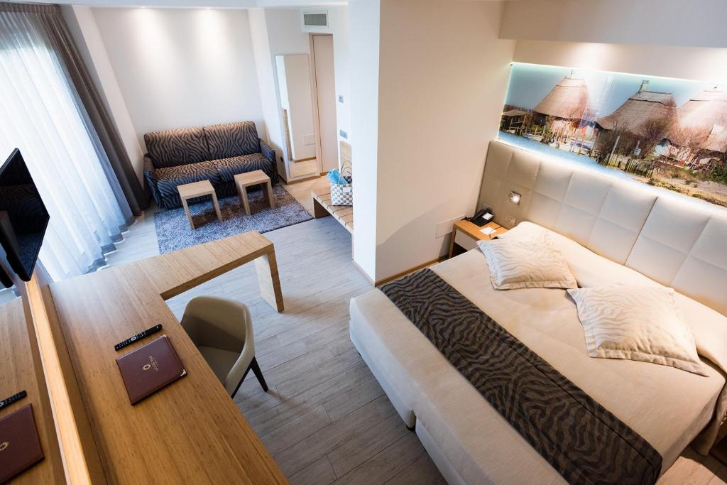 a bedroom with a bed and a table and a couch at Laguna Park Hotel 4Superior in Bibione