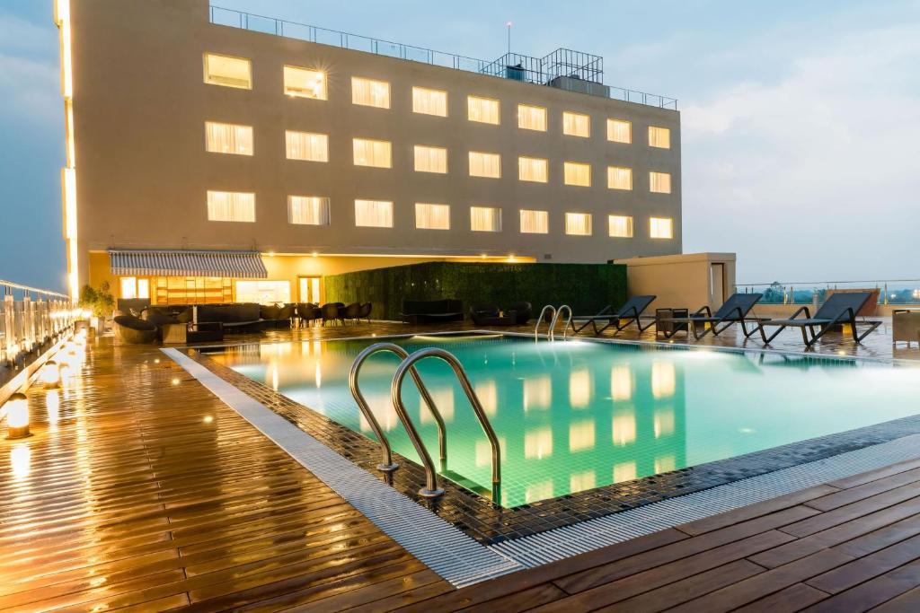 a large swimming pool in front of a building at Vivanta Chitwan Bharatpur in Bharatpur