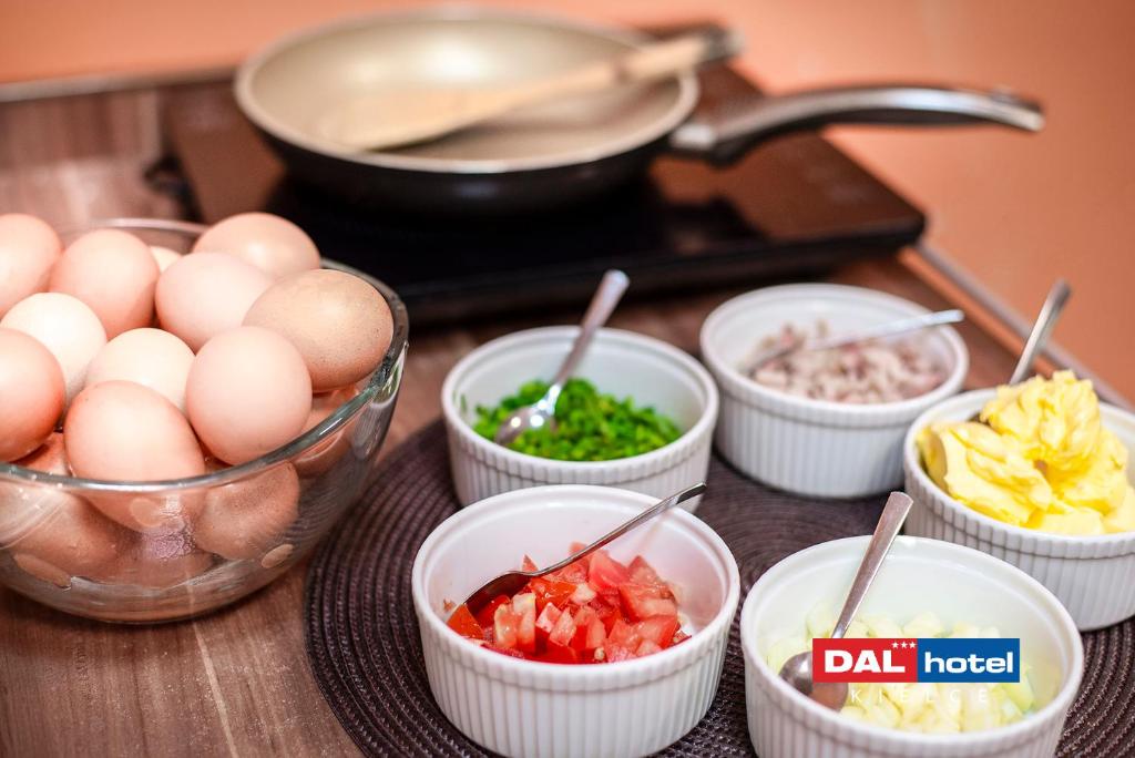Breakfast station with bowl of eggs, bowls of chopped toppings, and frying pan in background.