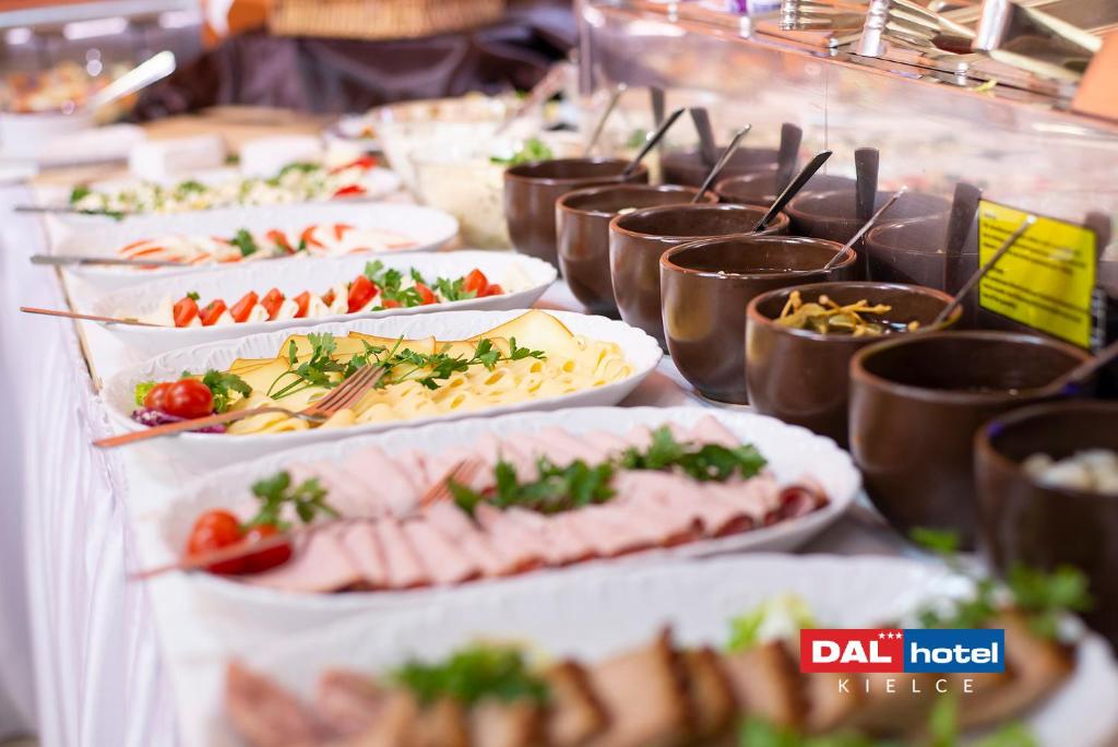 Buffet table with arranged cold cuts, sliced cheese, garnishes, and rows of condiment bowls.