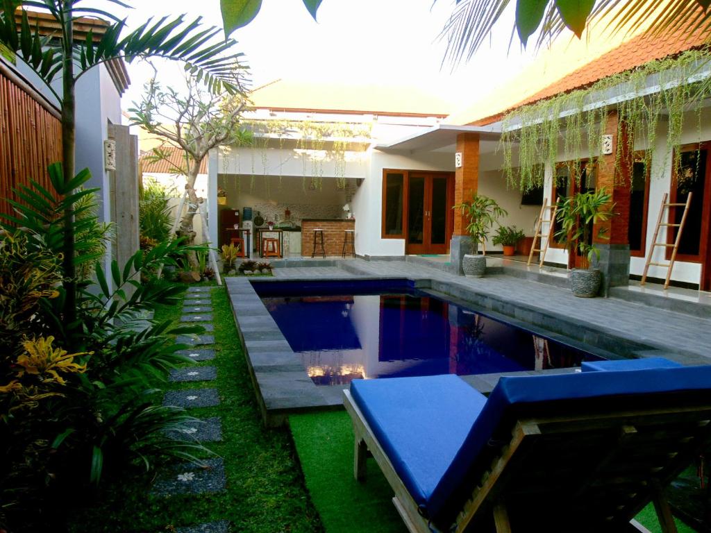 una piscina in un cortile con una casa di The Jepun Room and House a Canggu