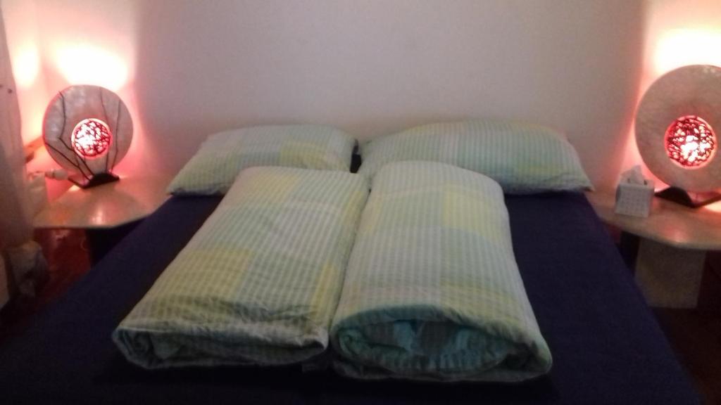 ein Bett mit vier Kissen und zwei Tischen in der Unterkunft Altstadtappartment in Altstätten