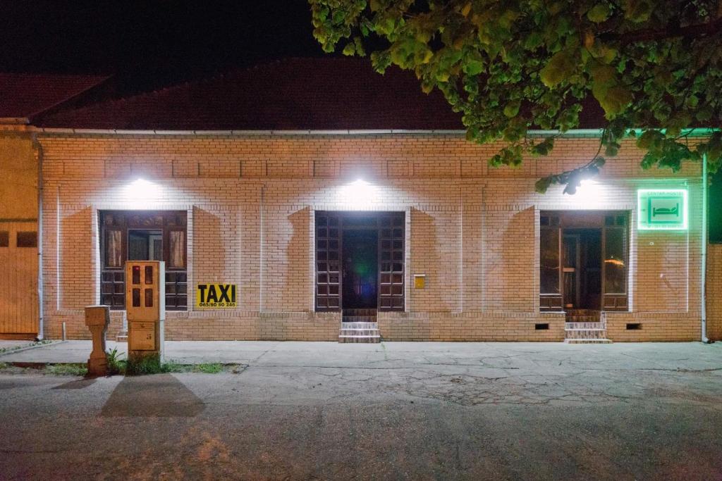 un edificio de ladrillo con luces encendidas por la noche en Hostel Horgos Centar en Horgoš