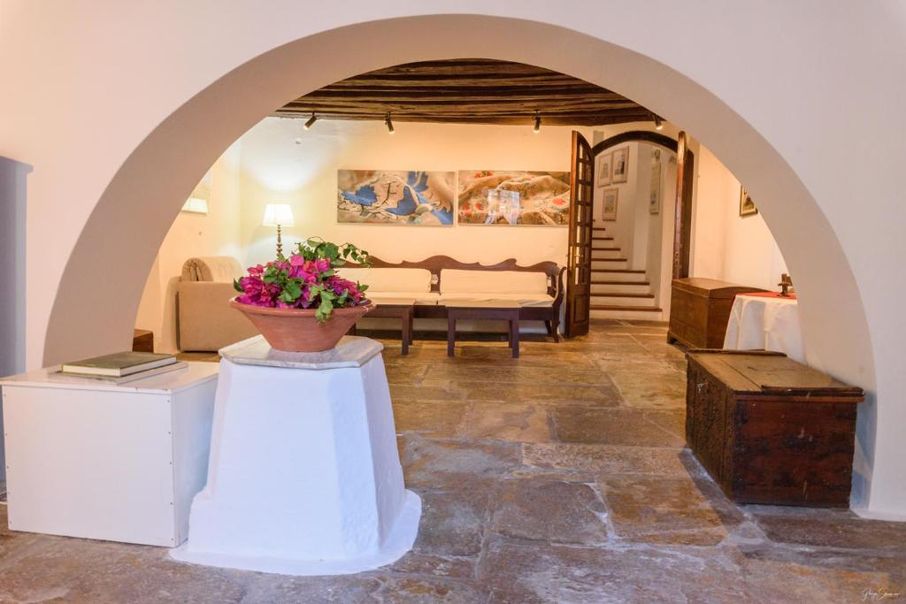 a living room with an archway and a couch at Hotel Miranda in Hydra