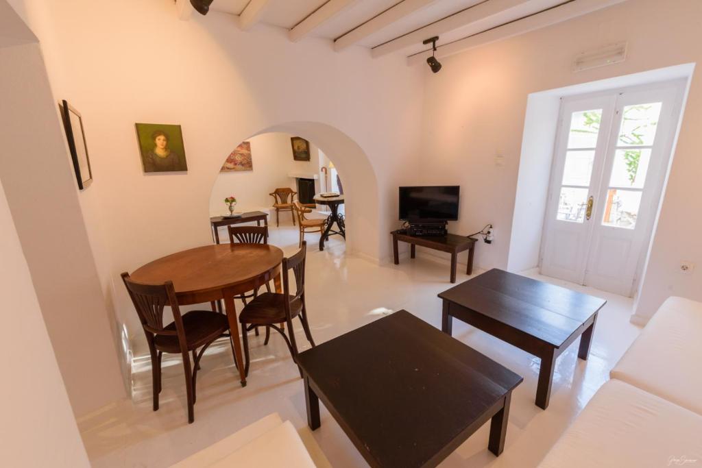 a living room with a table and chairs and a tv at Hotel Miranda in Hydra