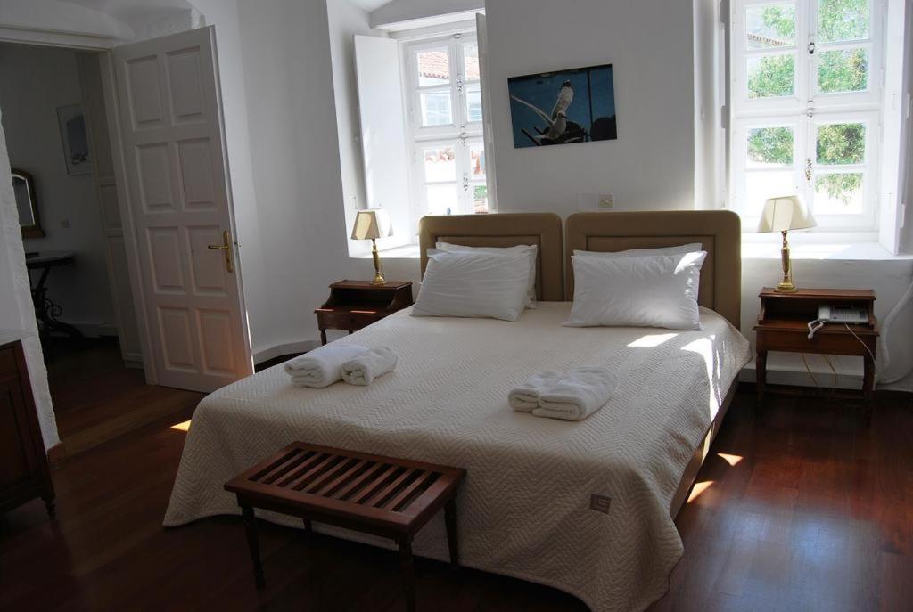 a bedroom with a bed with towels on it at Hotel Miranda in Hydra