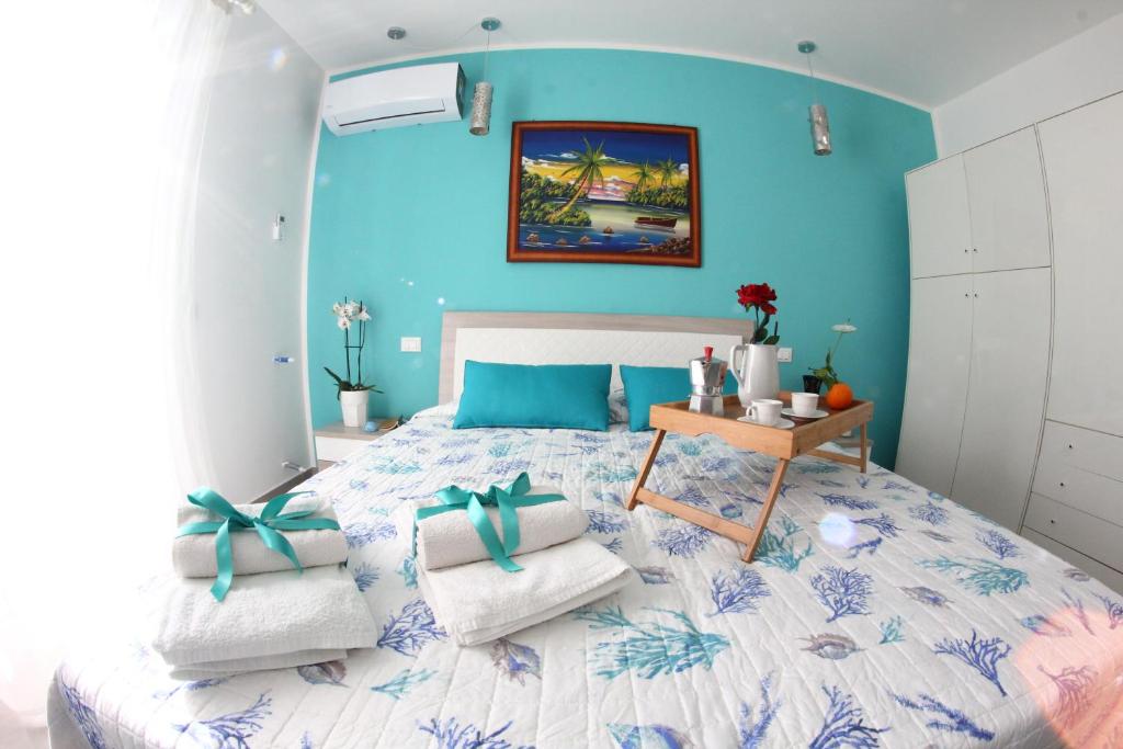a bedroom with a large bed with a blue wall at APPARTAMENTO L'AIRONE in Balestrate