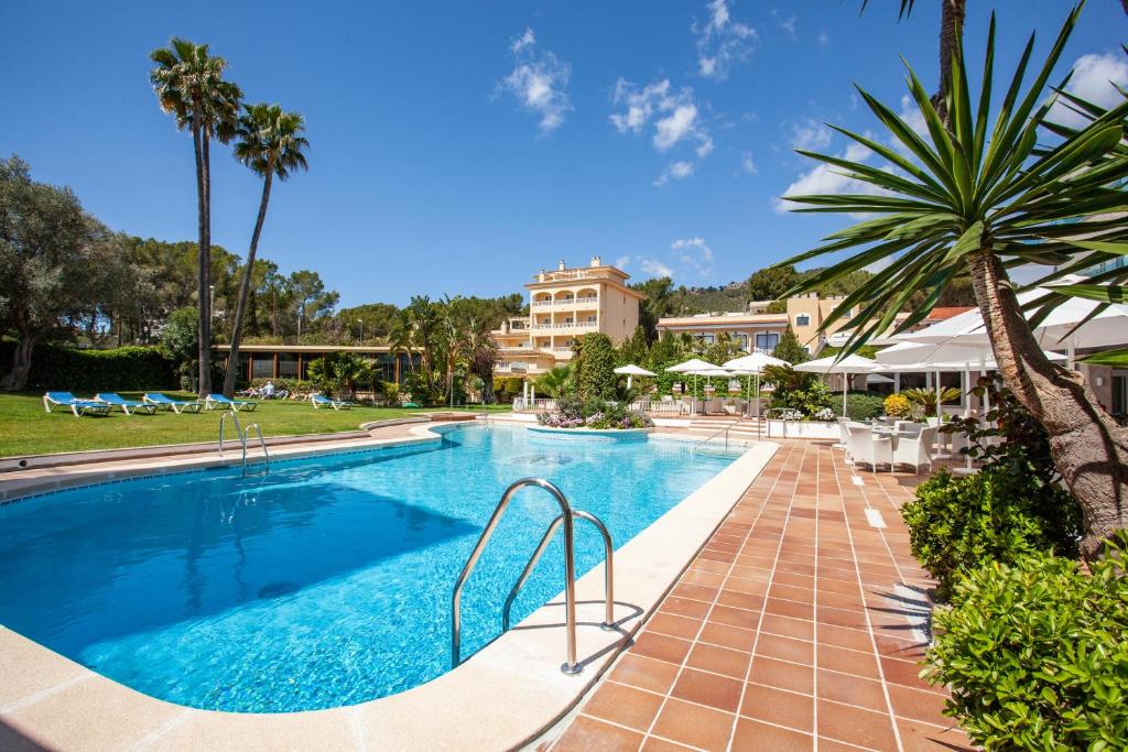einen Pool in einem Resort mit Tischen und Sonnenschirmen in der Unterkunft Grupotel Nilo & Spa in Paguera