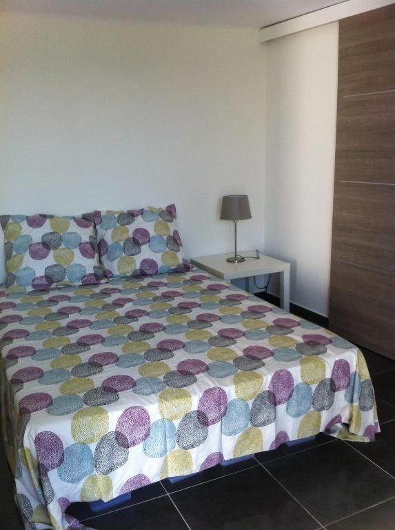 a bedroom with a bed with a colorful comforter at Gîte Polema in Marseille
