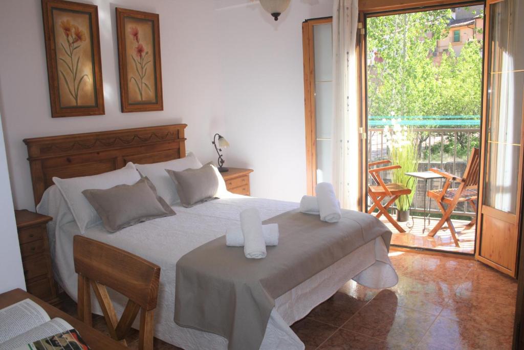 Casa Rural Arenal في Torrijo de la Cañada: غرفة نوم مع سرير مع وجود شمعتين عليه