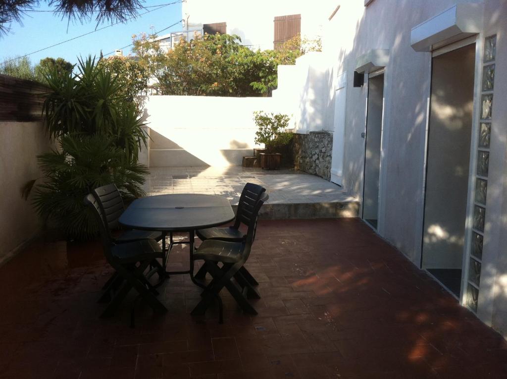 a patio with a table and chairs on a balcony at Gîte Polema in Marseille