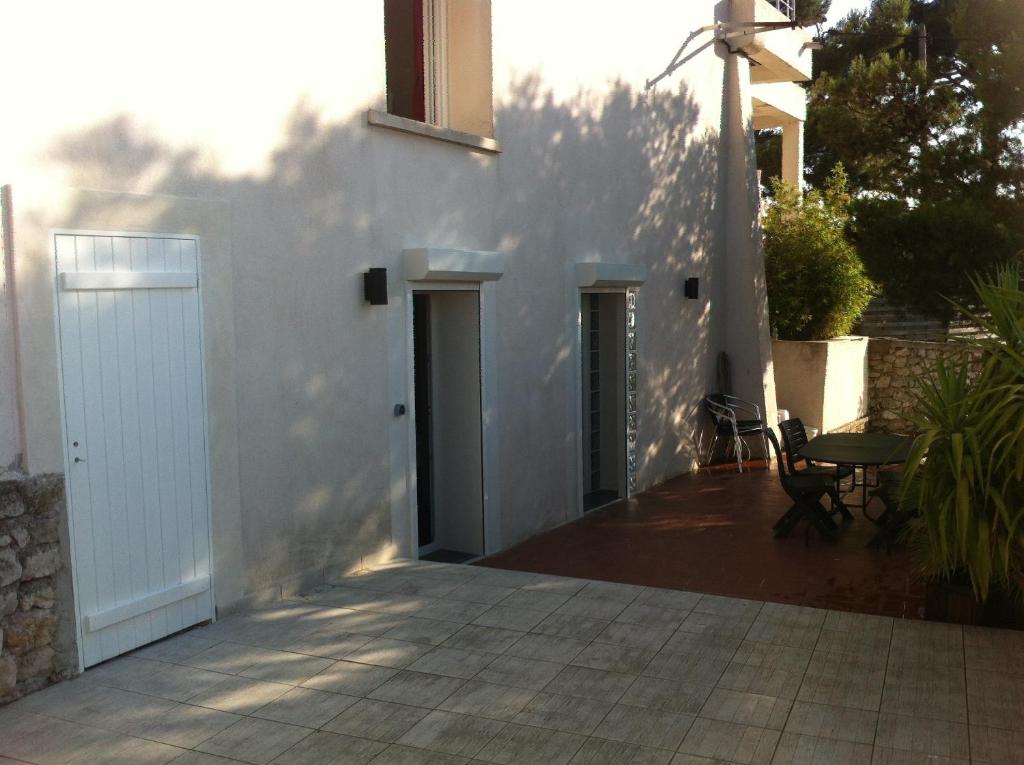 a white house with a white door and a patio at Gîte Polema in Marseille