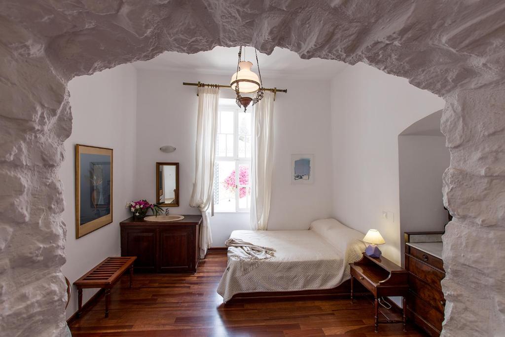 a bedroom with a bed and a window at Hotel Miranda in Hydra