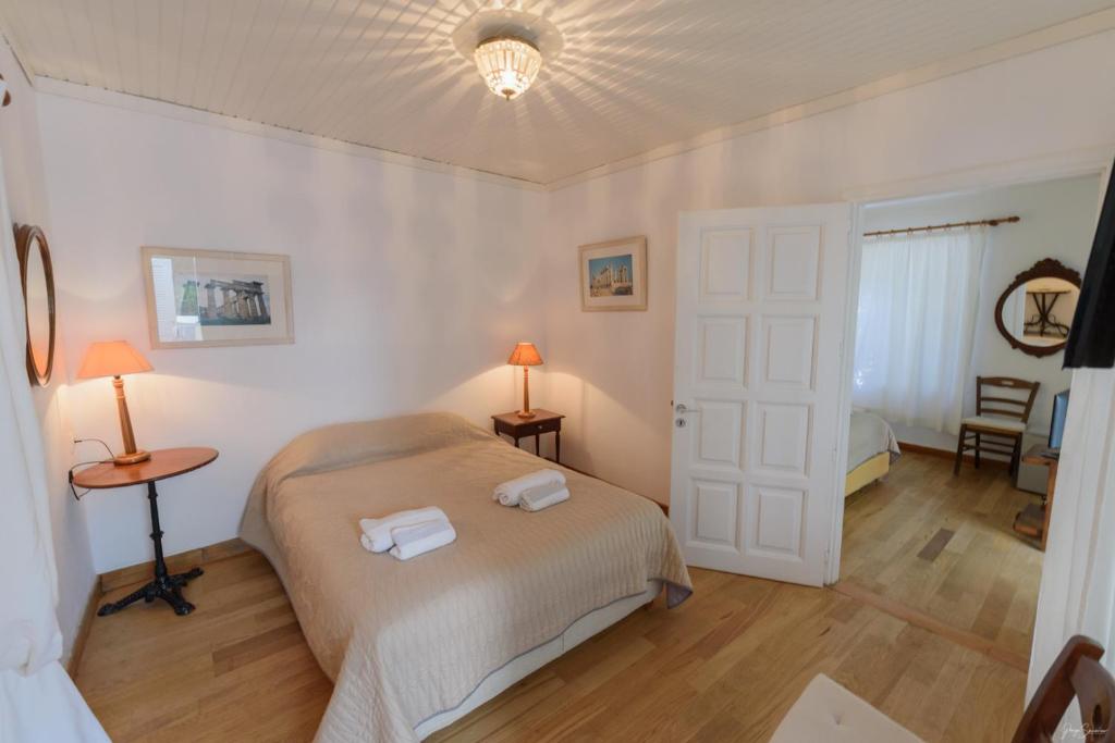 a bedroom with a bed with two towels on it at Hotel Miranda in Hydra