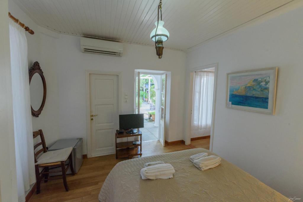 a bedroom with a bed with two towels on it at Hotel Miranda in Hydra