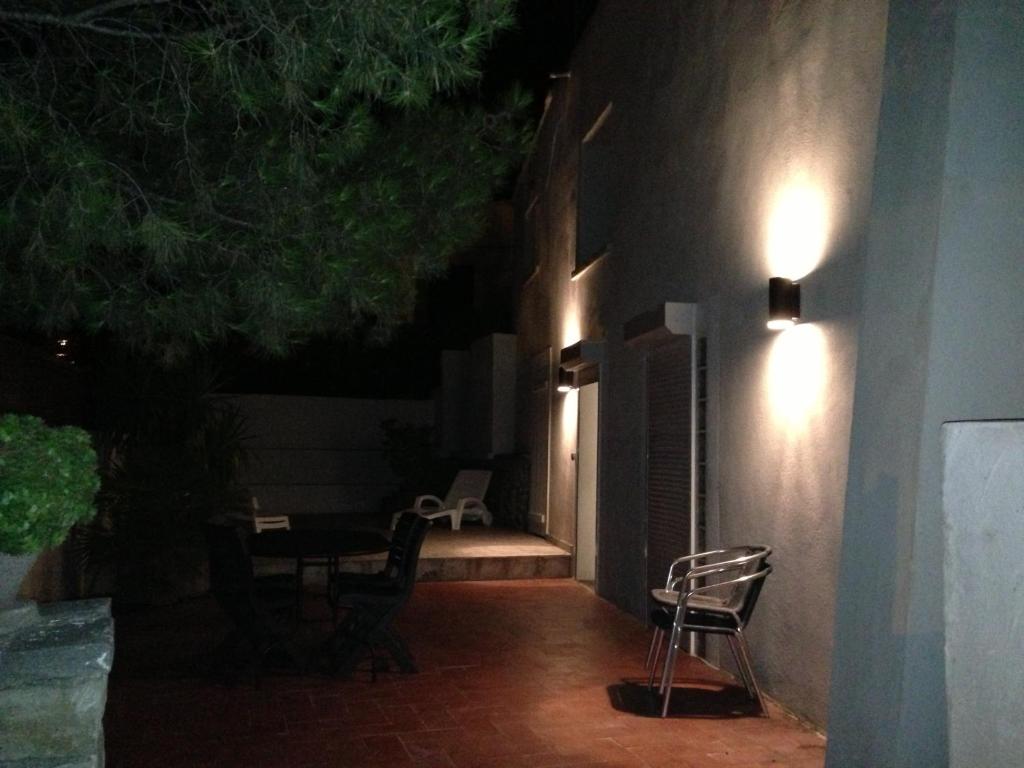 a patio at night with a table and chairs at Gîte Polema in Marseille