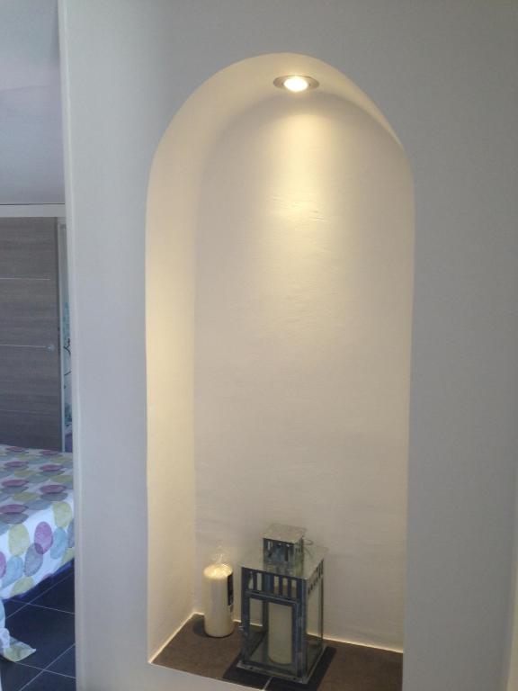 a room with a white wall with a candle and a bed at Gîte Polema in Marseille