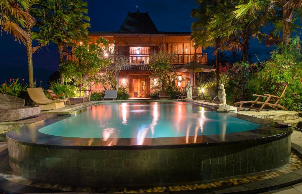 a swimming pool in the middle of a backyard at night at Ti Amo Bali in Jatiluwih