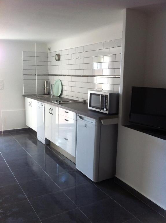 a kitchen with white cabinets and a microwave at Gîte Polema in Marseille