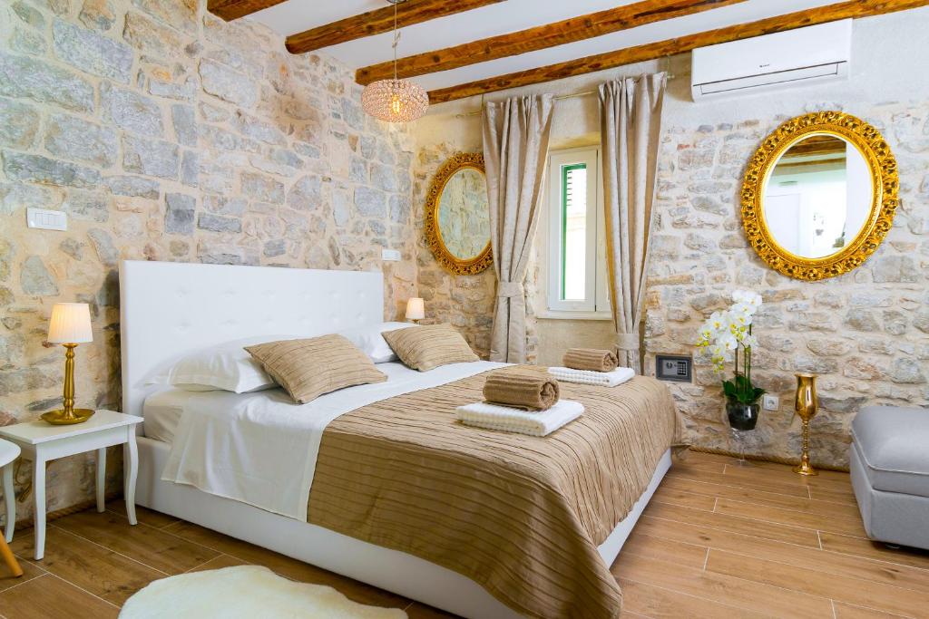 a bedroom with a large bed and a stone wall at LUX AURELIUS in Split Centre Old Town in Split