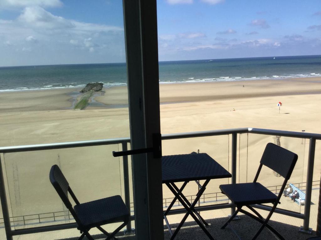 a view of a beach with two chairs and a table at Melanie in Middelkerke