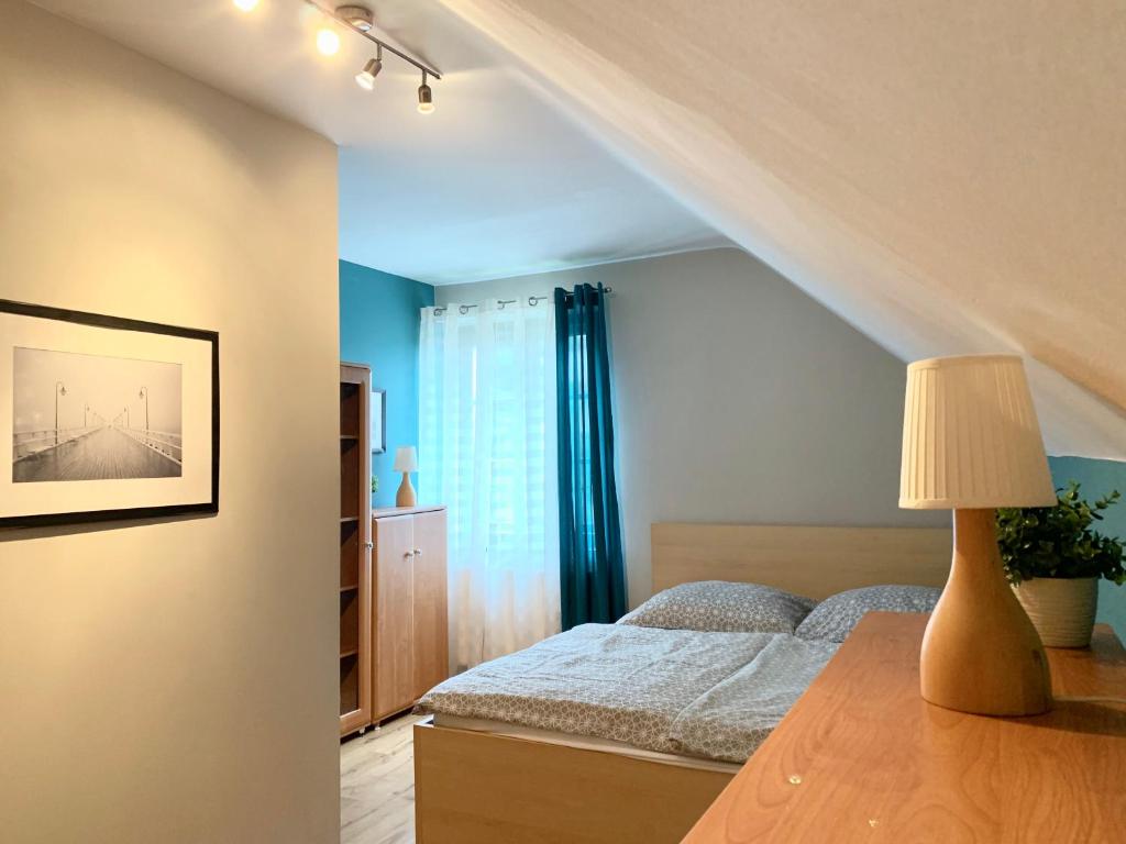 グディニャにあるKwatera Orłowskaのベッドルーム1室(ベッド1台、ランプ付きテーブル付)