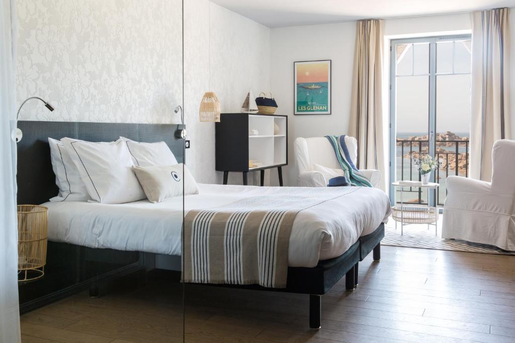 a bedroom with a large bed and a balcony at Castel Beau Site in Perros-Guirec