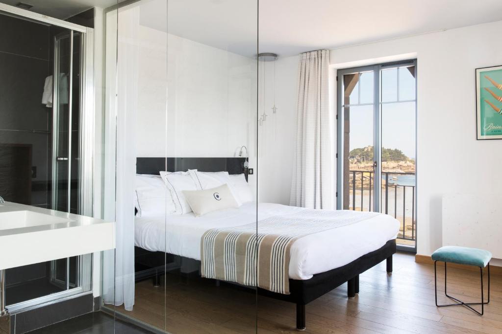 a bedroom with a bed with a glass wall at Castel Beau Site in Perros-Guirec