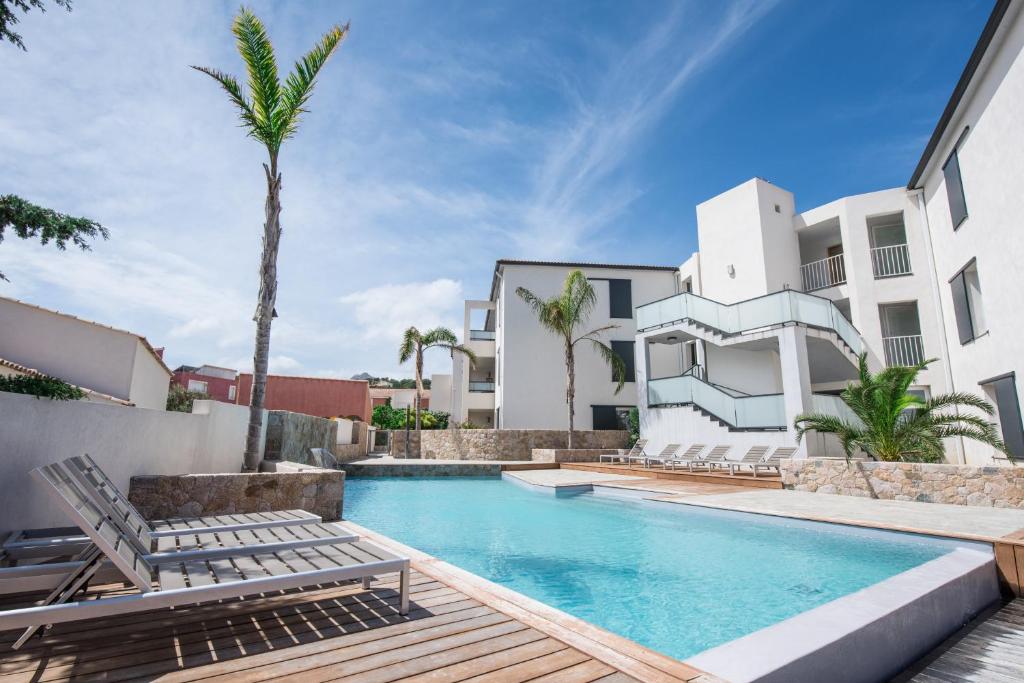 a swimming pool with chaise lounge chairs next to a building at Les Alizés Résidence & Spa in Monticello