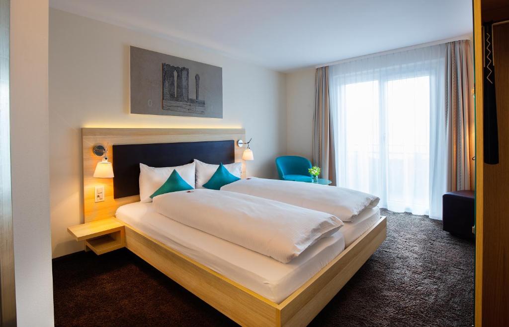 a hotel room with a large bed and a window at Hotel Oberland in Triesenberg