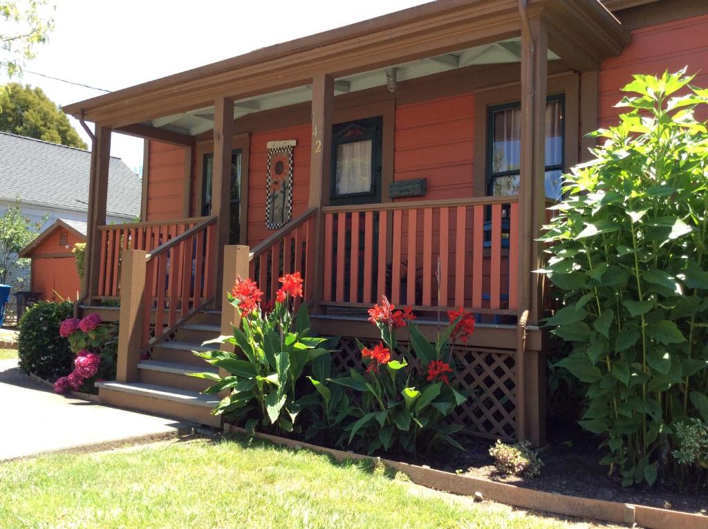 a small orange house with a porch and flowers at Historic Santa Rosa Cottage in Santa Rosa